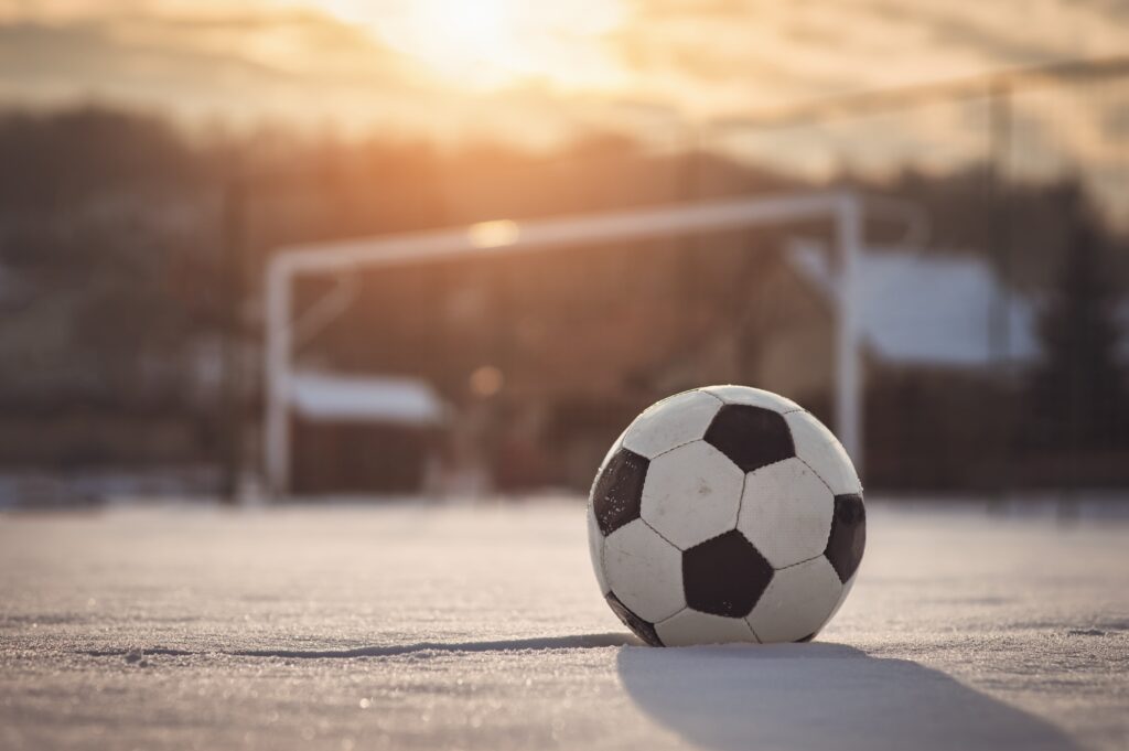 A football on a snowy football pitch